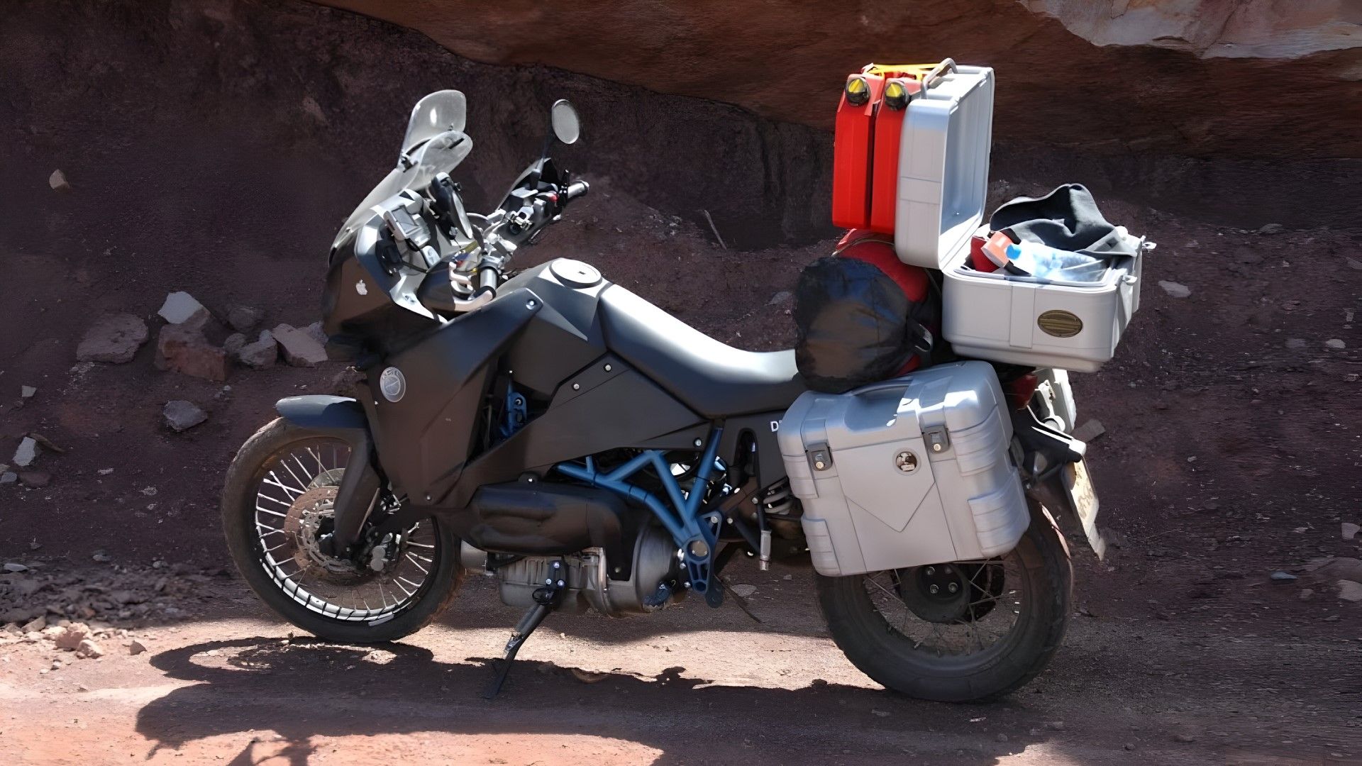 Vista lateral do perfil da motocicleta de aventura a diesel EVA Track T-80 totalmente carregada e pronta para turismo