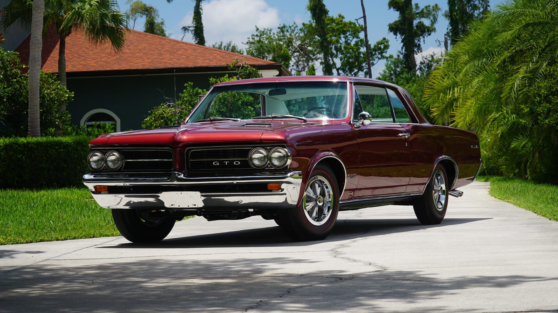 Pontiac GTO Hardtop 1964 com vista frontal vermelha do terceiro quarto
