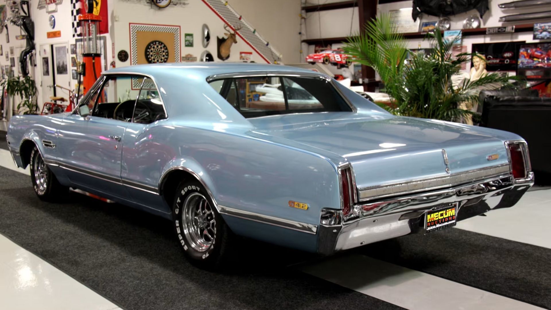 Traseira de um Olds 442 prateado de 1966 no showroom