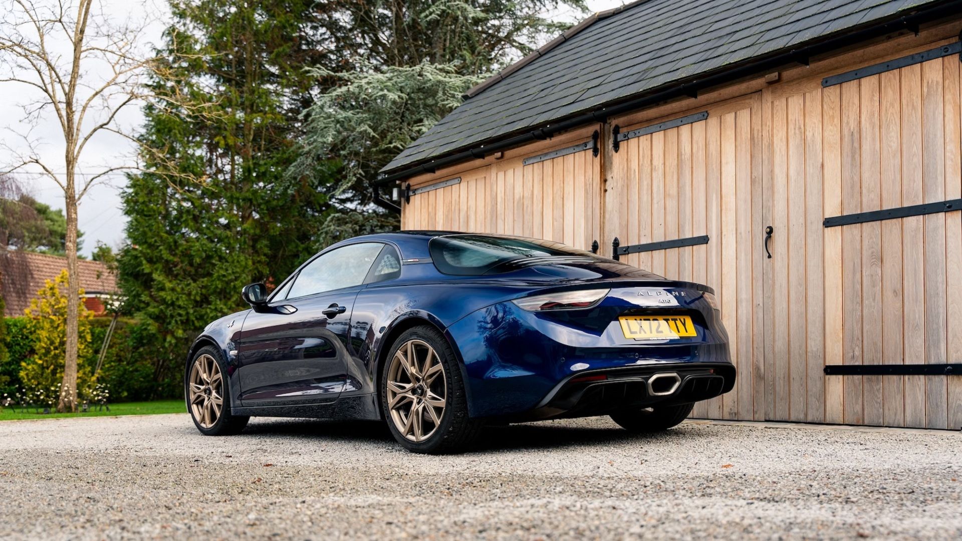 Traseira do Alpine A110 azul no cascalho