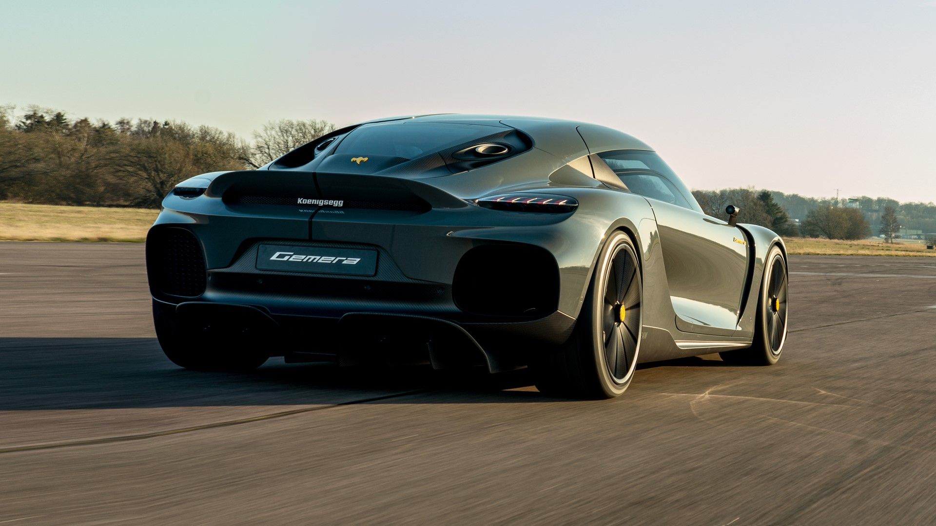 Koenigsegg Gemera na estrada acelerando vista traseira do terceiro quarto