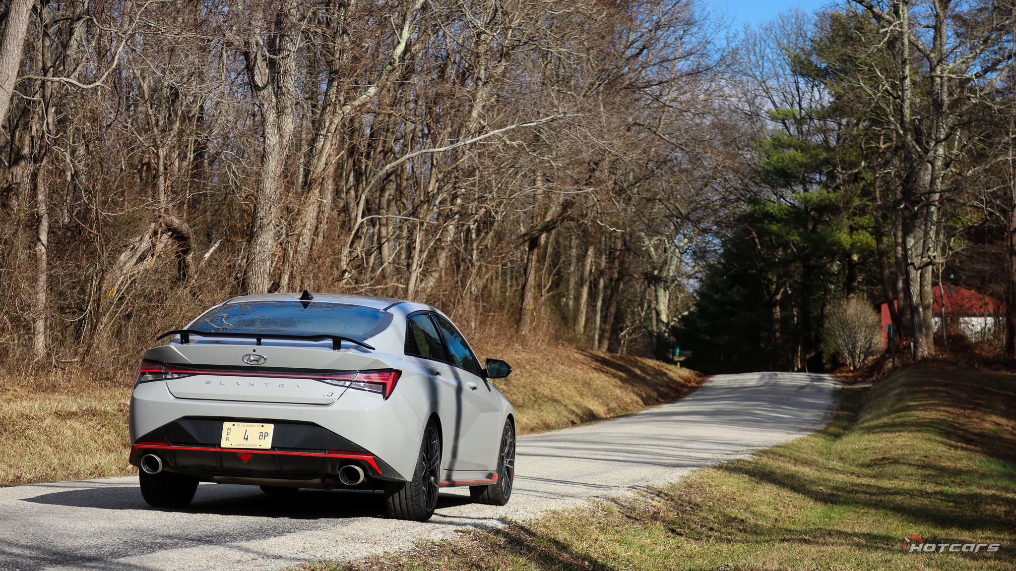 Hyundai Elantra N 2023 года, припаркованный сзади красный дом