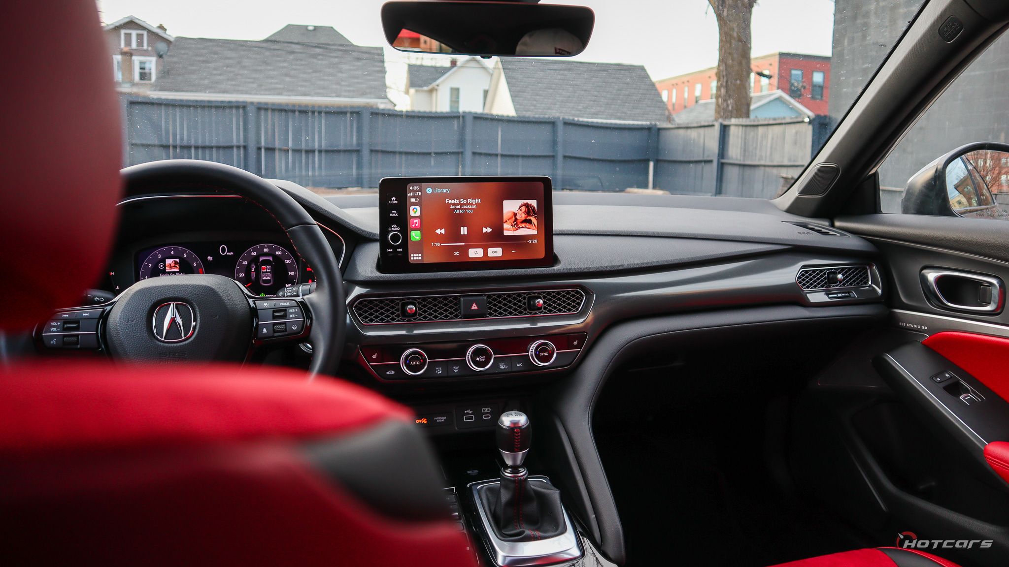 Вид на приборную панель Acura Integra 2023 года через красное сиденье